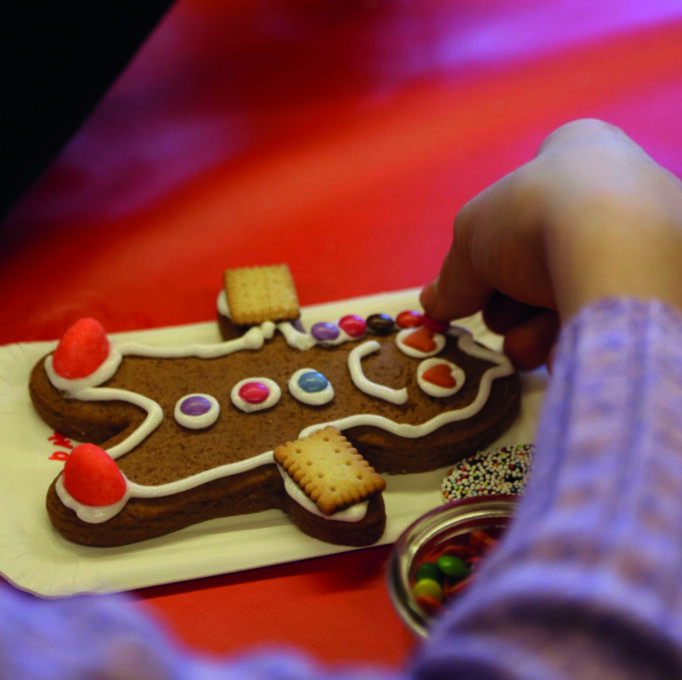 Ein Lebkuchenmännchen wird mit Süßigkeiten dekoriert.