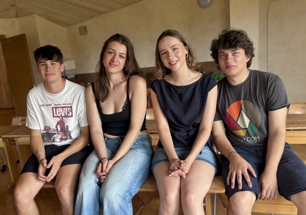 2 Jungs und 2 Mädchen aus der Oberstufe sitzen nebeneinander.