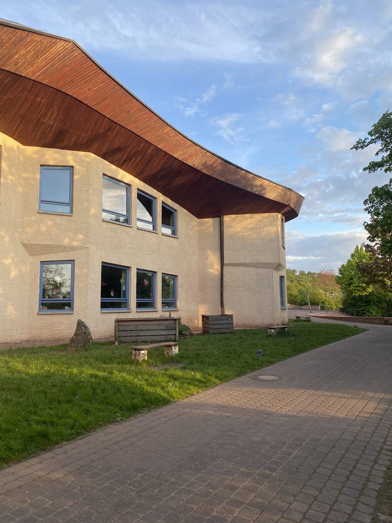 Das Schulgebäude der Waldorfschule Trier bei blauem Himmel in der Seitenansicht.