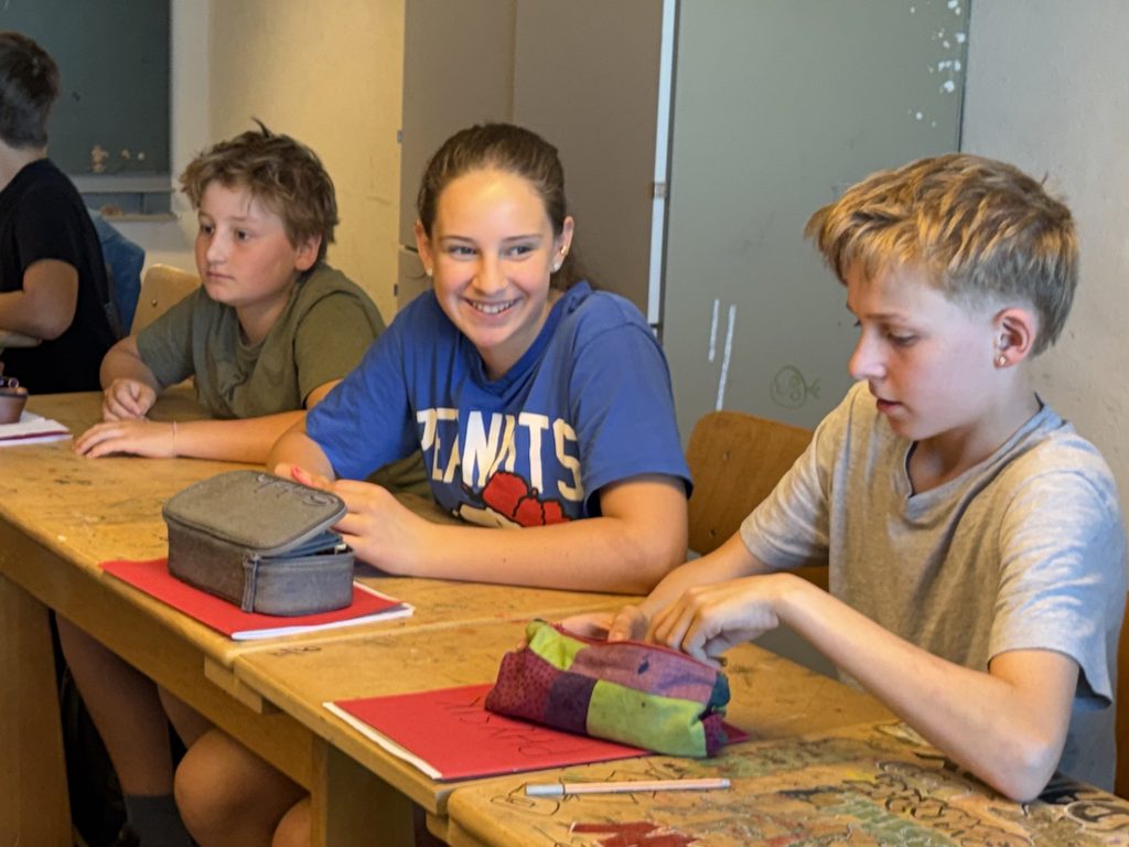 3 SchülerInnen im Klassenraum.